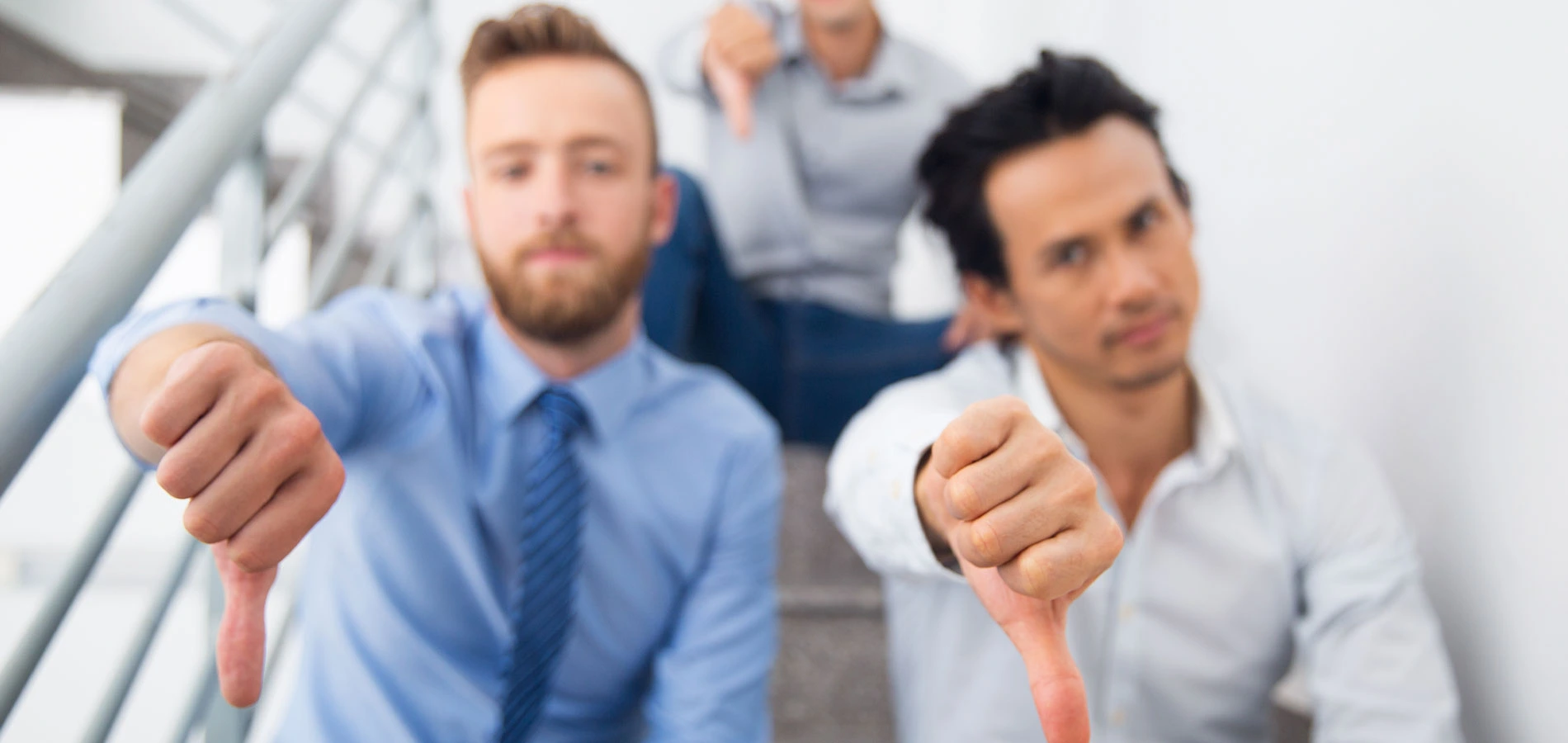 Photo of two employees wearing formal attire doing thumbs down