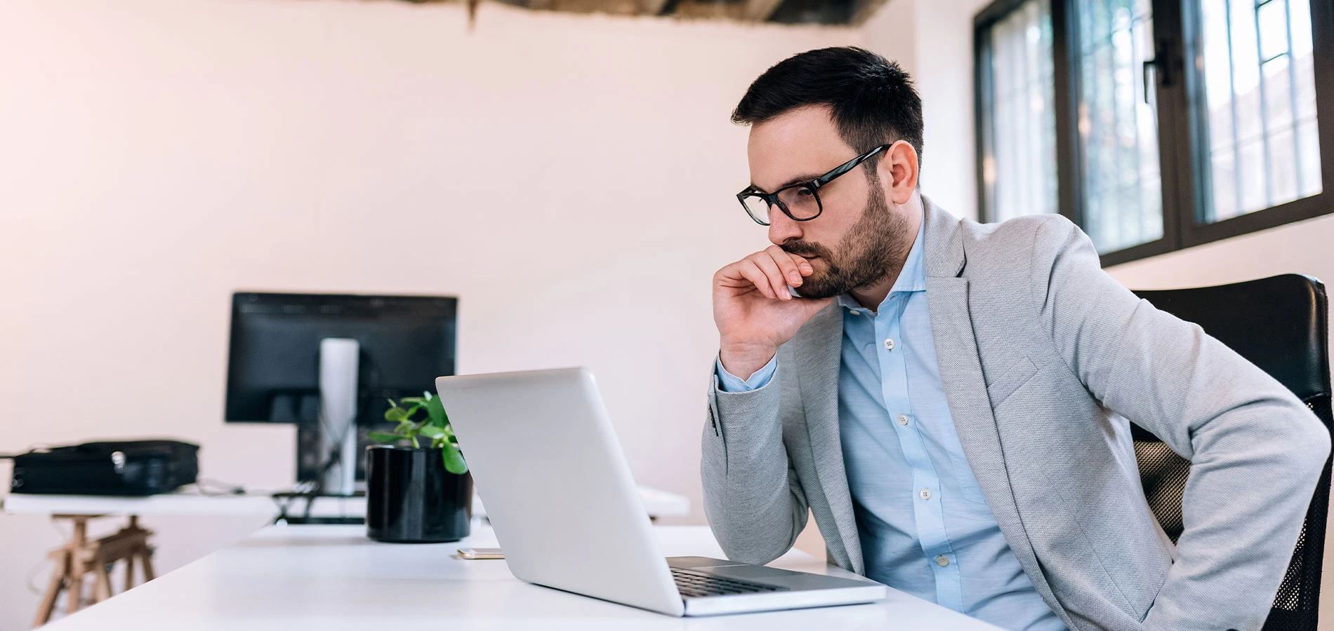 Serious businessman looking at laptop screen