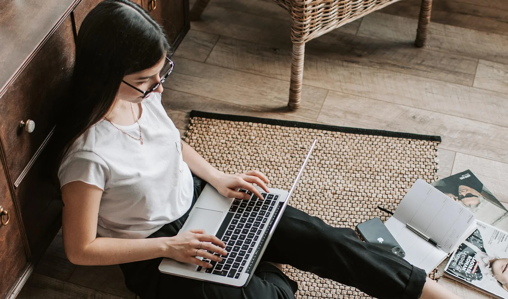 Young businesswoman with laptop sitting on floor