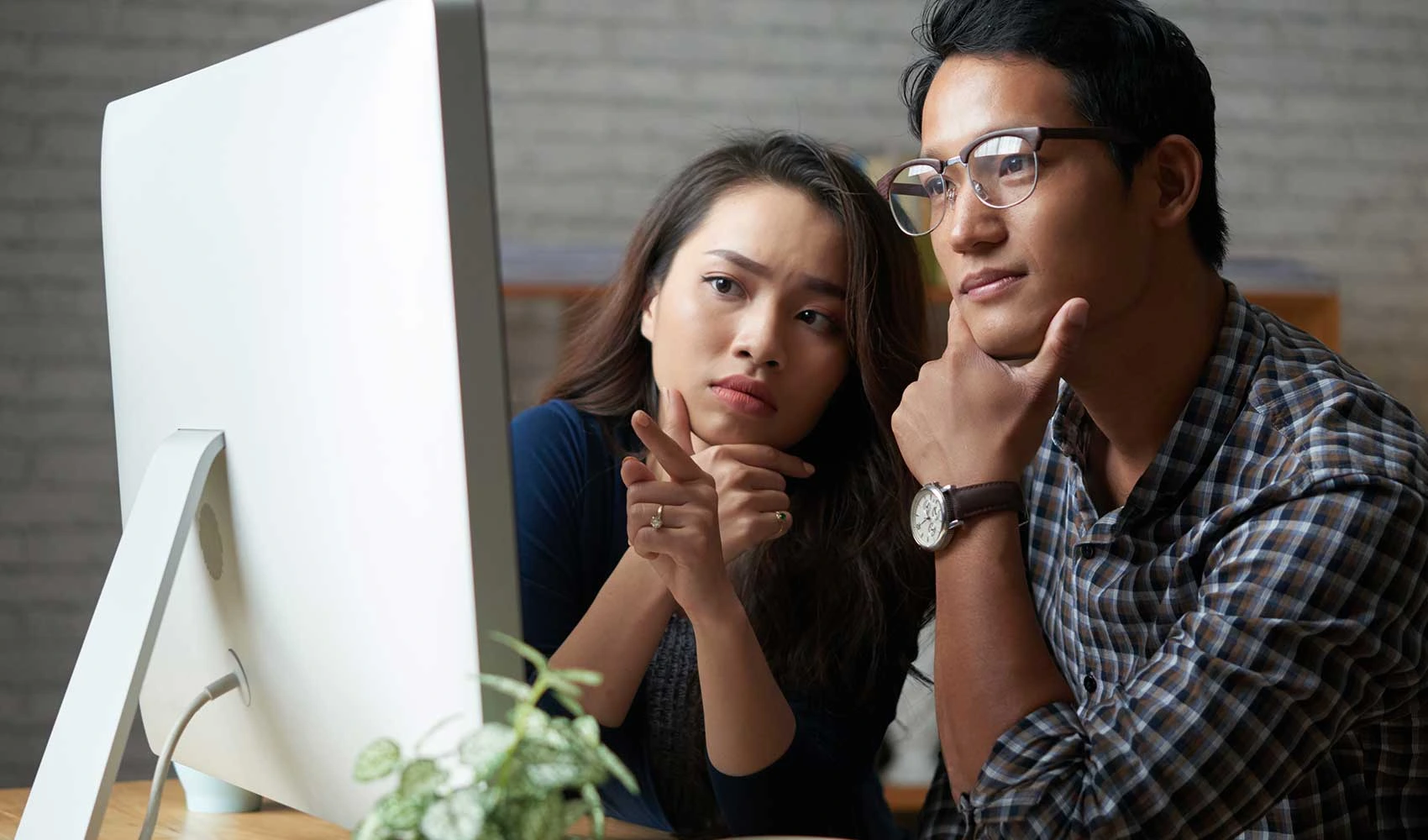 Employees thinking in front of a monitor