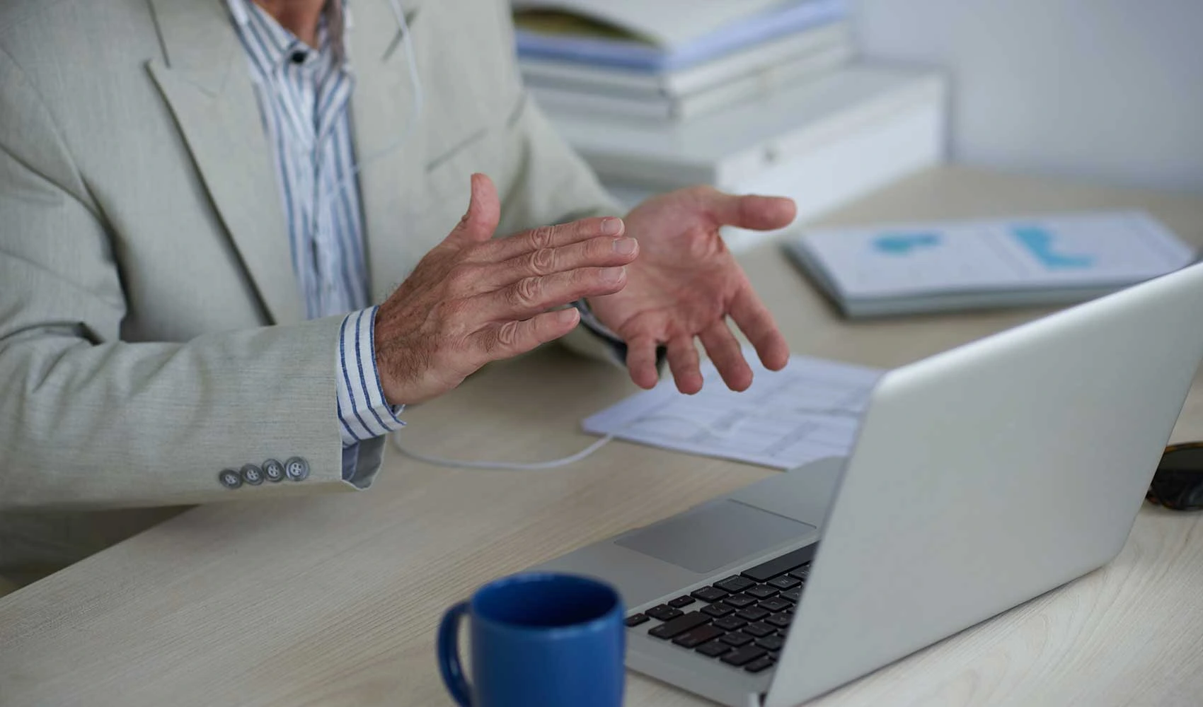 Cropped photo of a man clapping hands while in front of his laptop