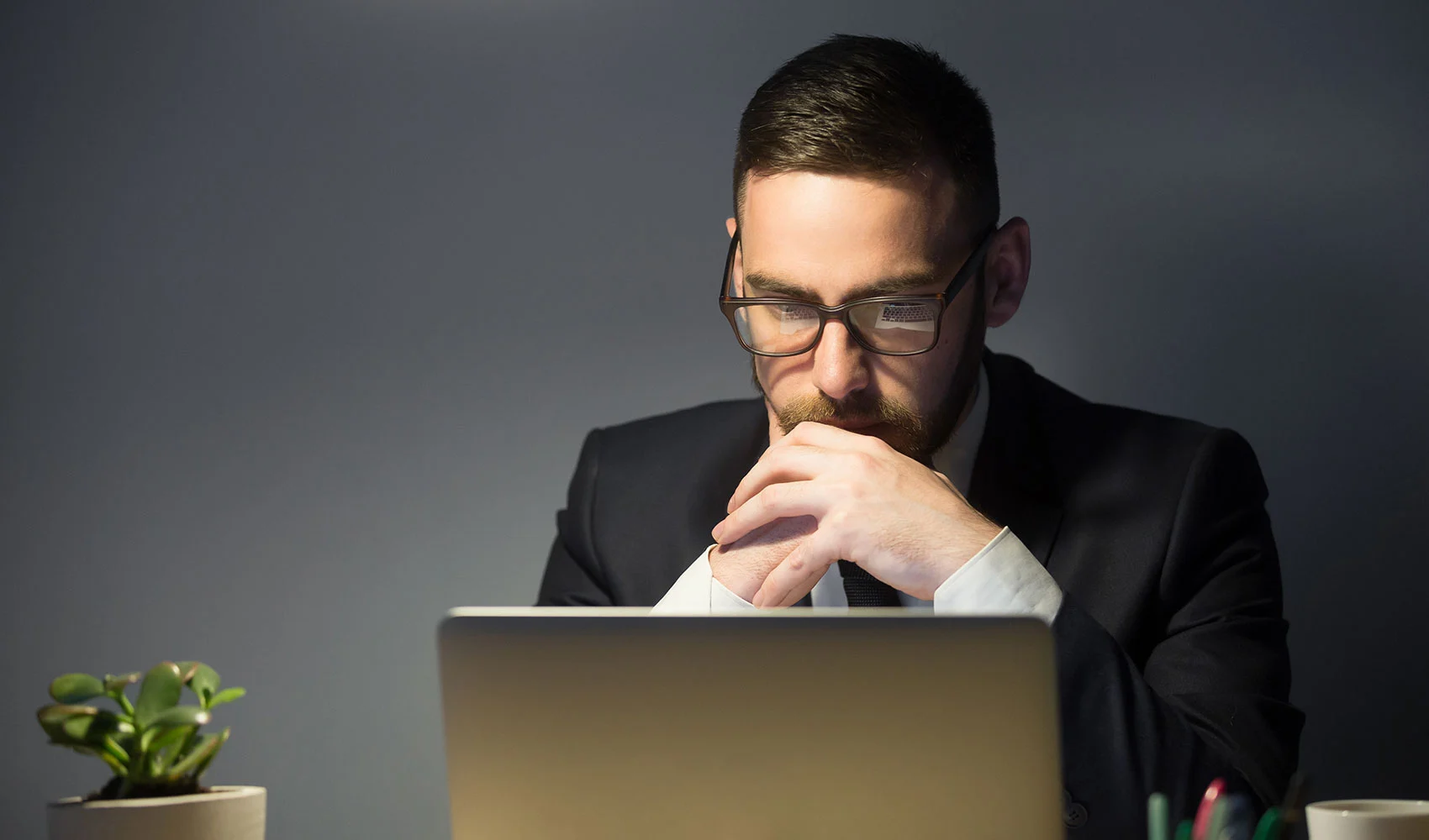 Serious man thinking in-front of his laptop