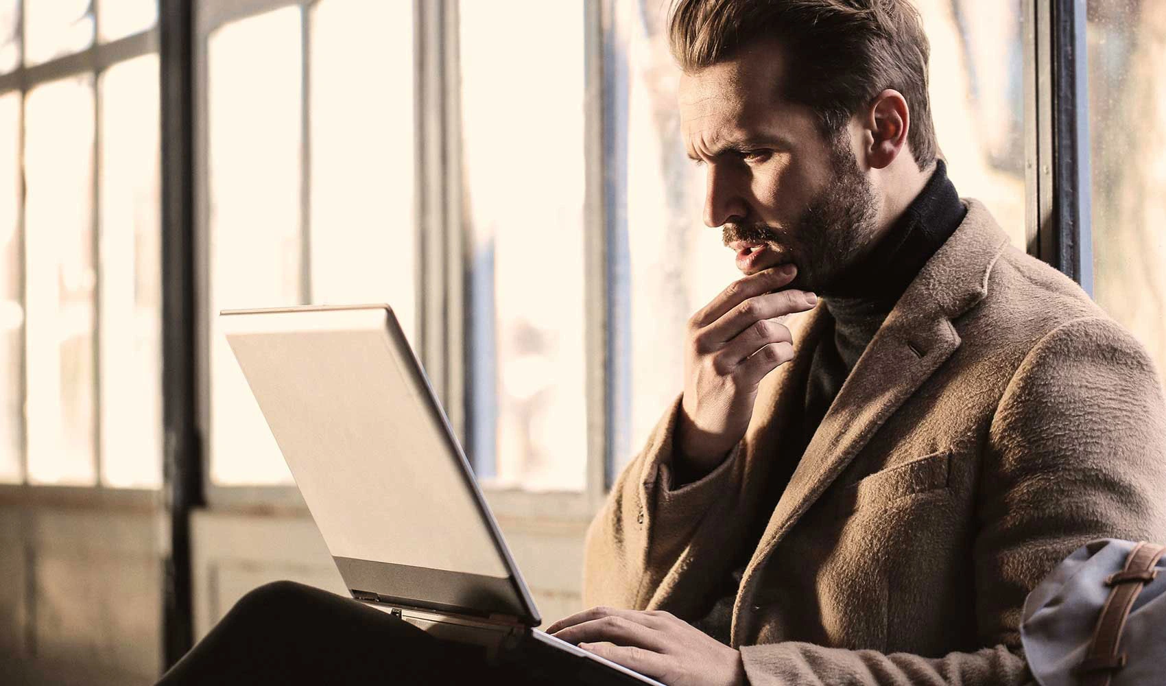 Man looking confused looking at his laptop