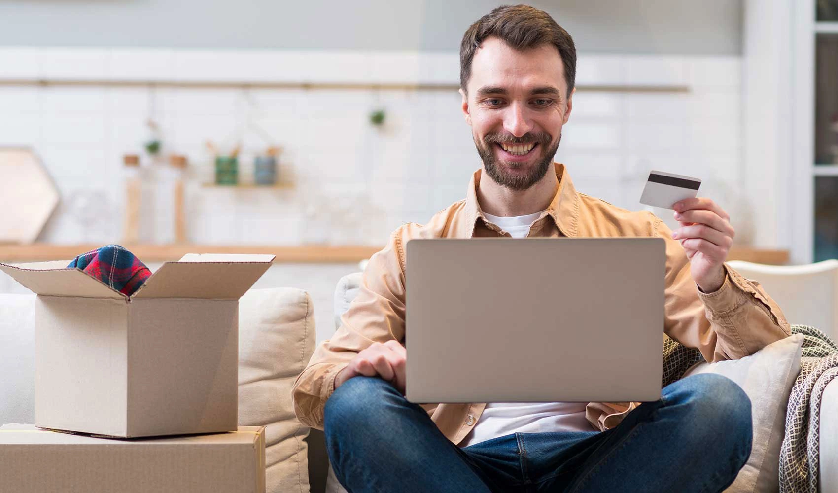 Man using a laptop while holding his credit card