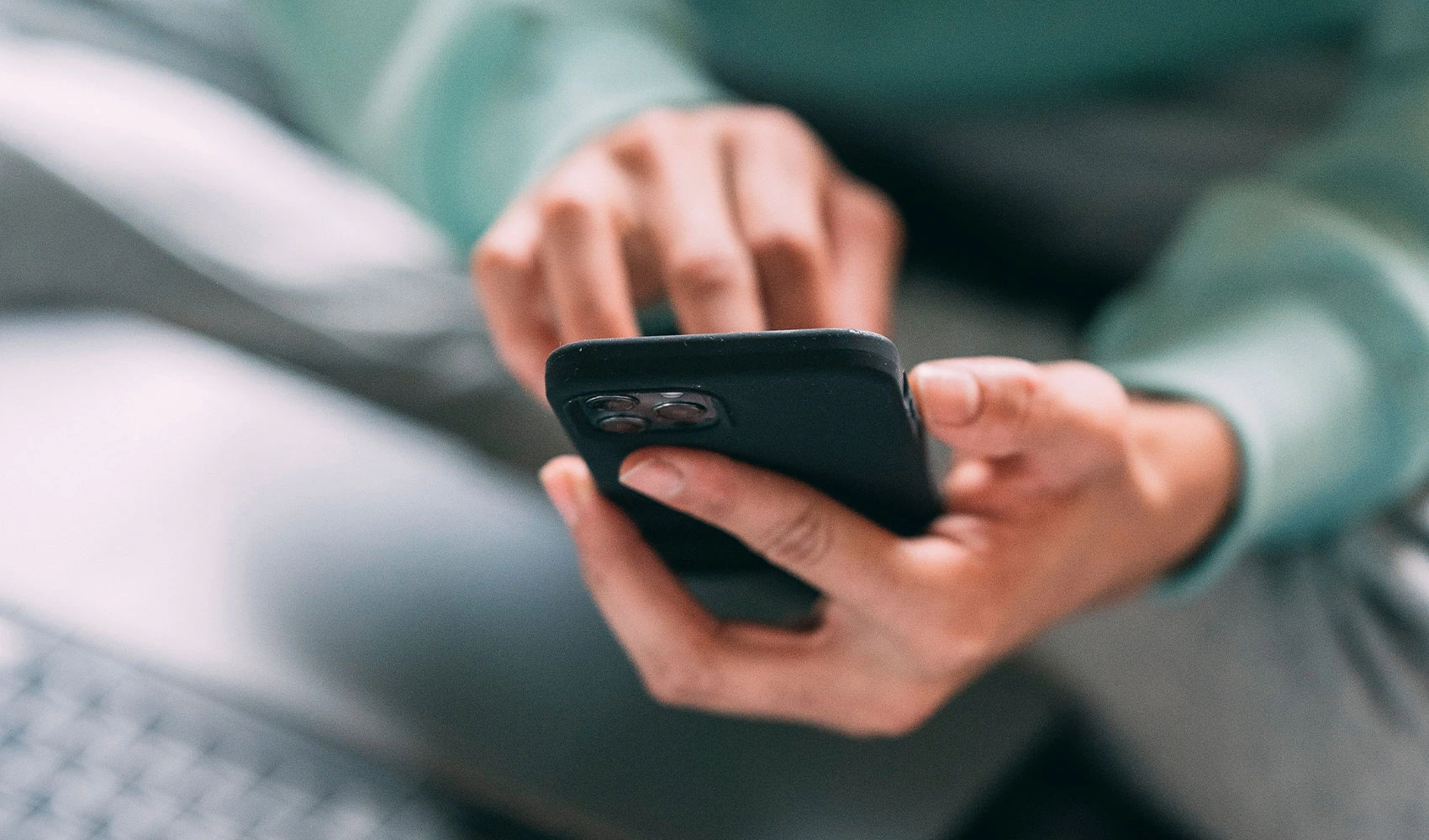Unrecognizable man browsing smartphone on bed