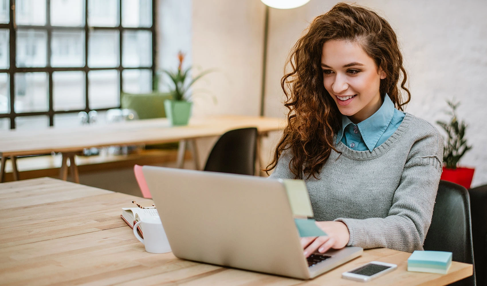 Young woman working with her laptop at modern office