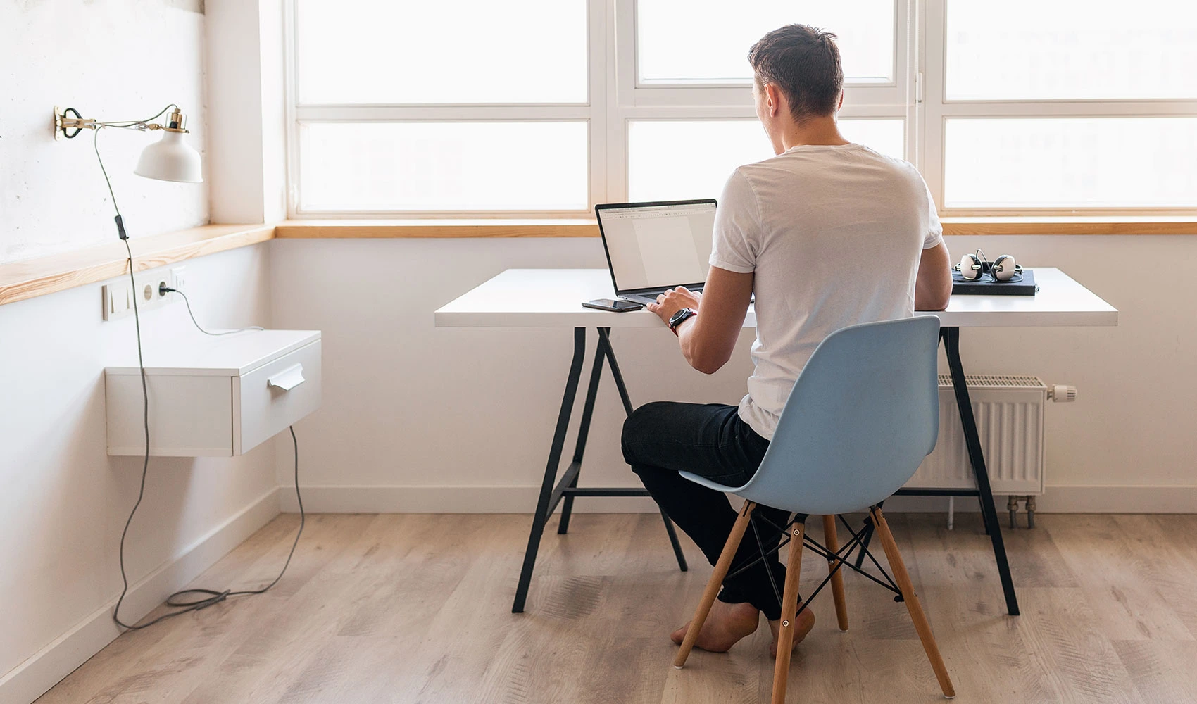 Back view of a man working from home