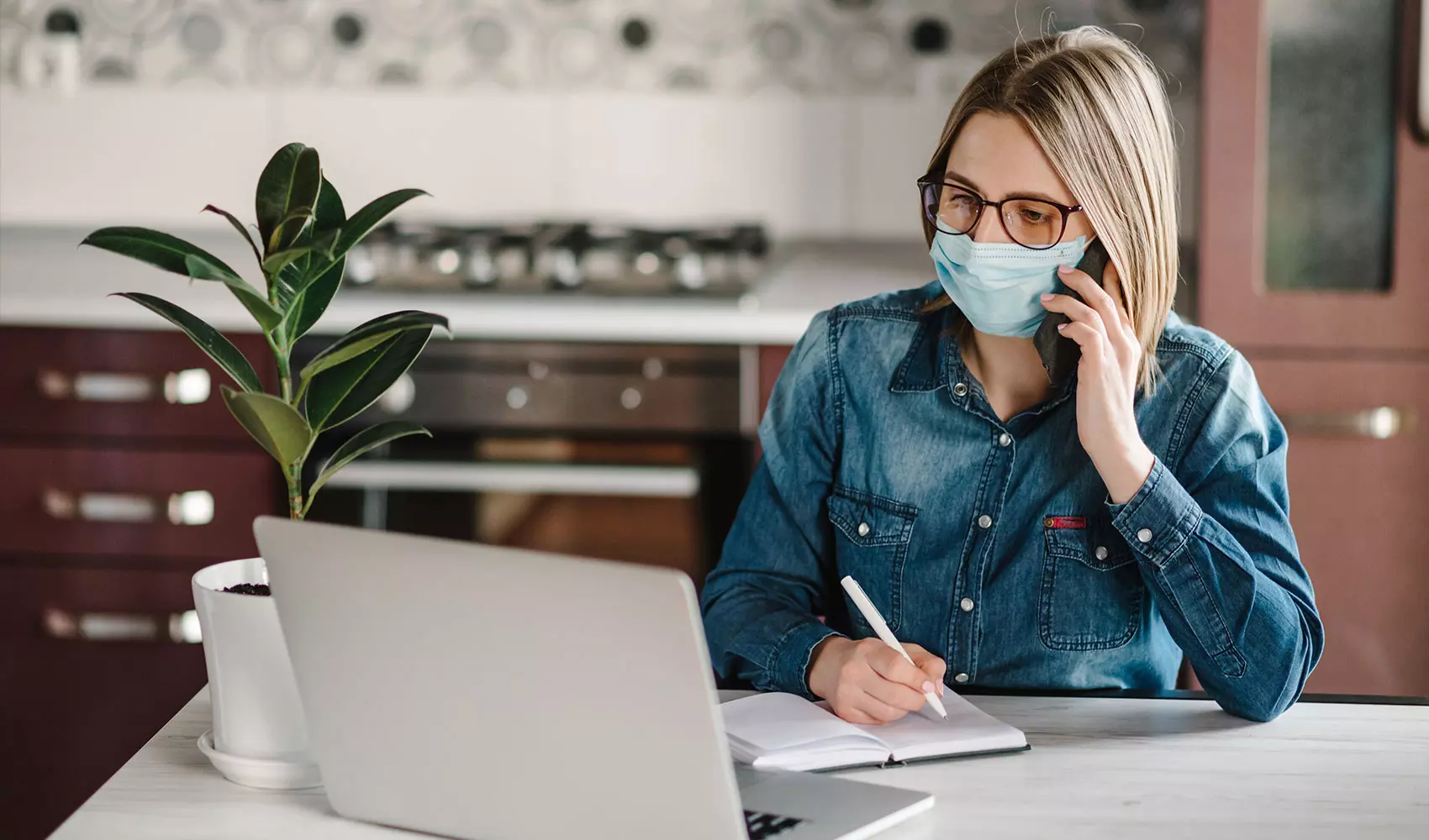 Woman wearing mask working at home