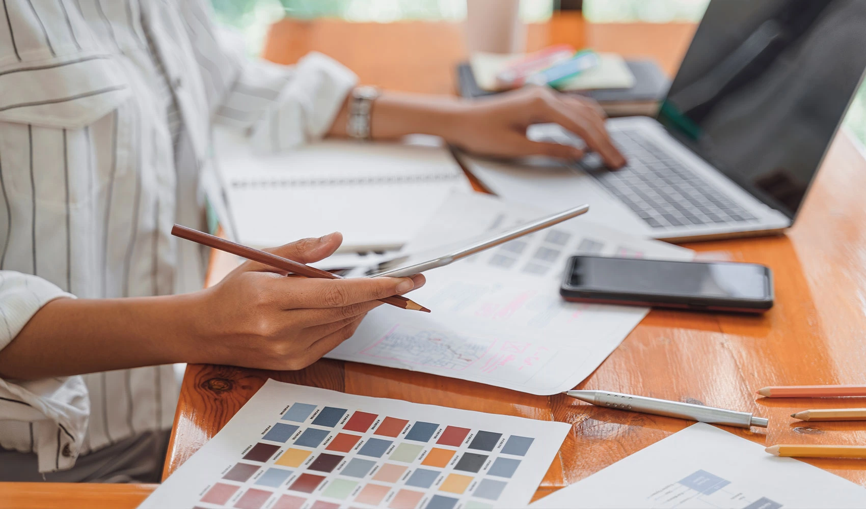 Graphic designer working on her iPad and laptop