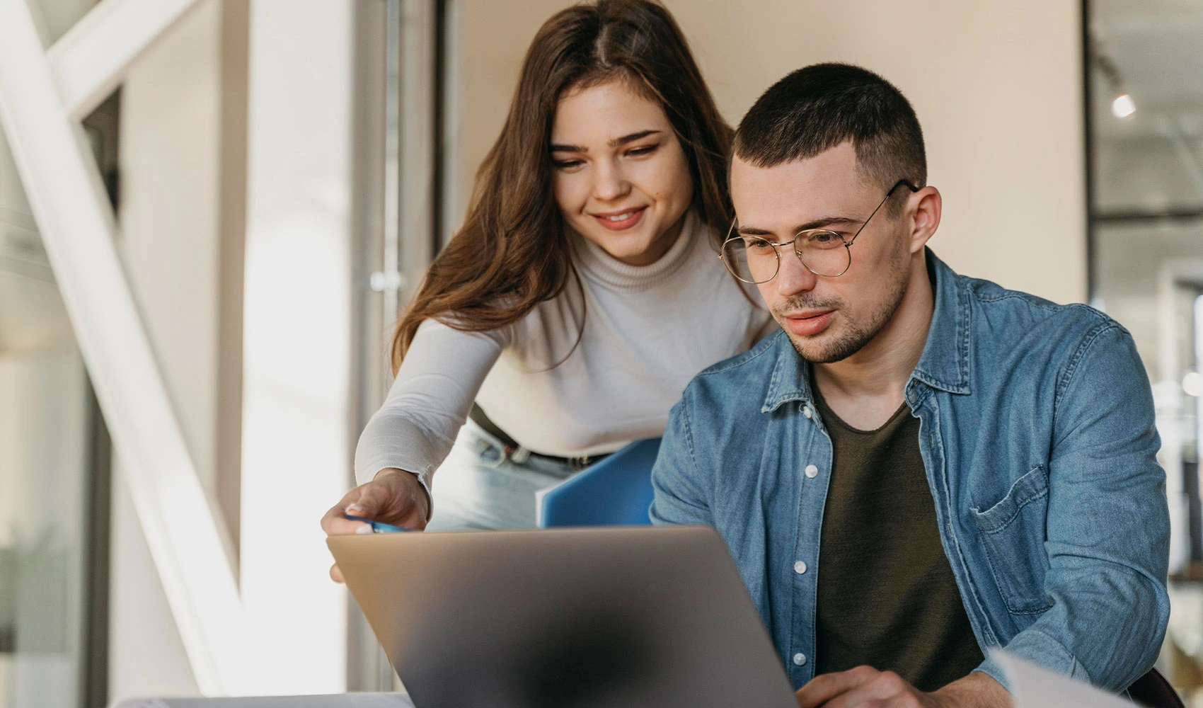 Two employees discussing in front of the laptop at the office