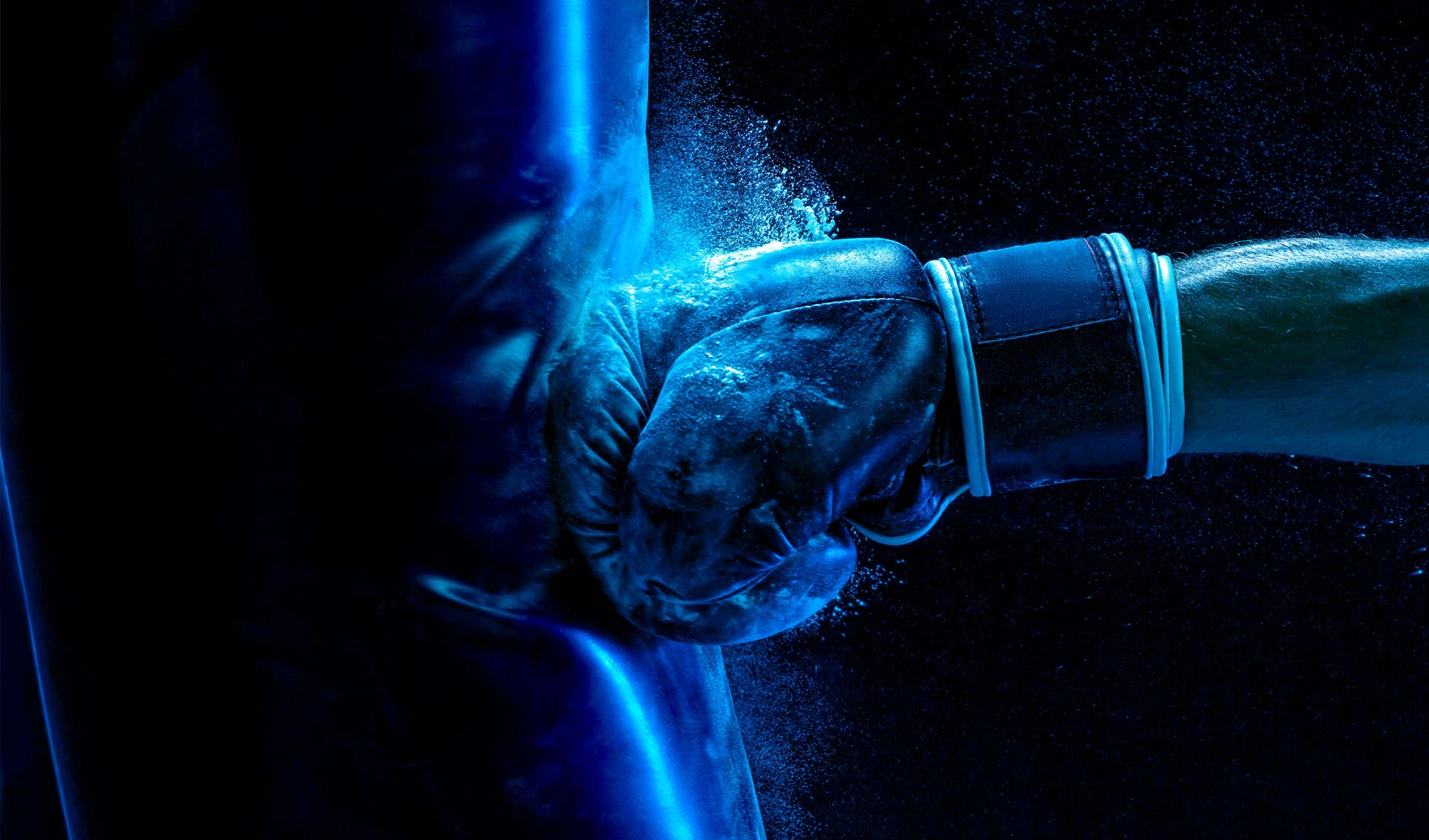 Closeup photo of a boxer hand punching a punching bag