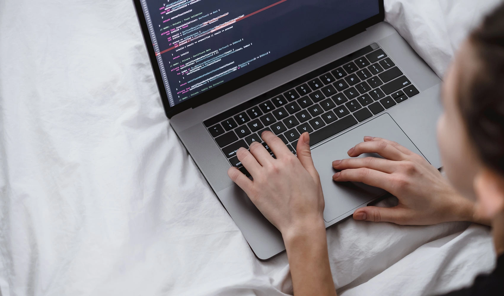 Young female writing a program code on her laptop