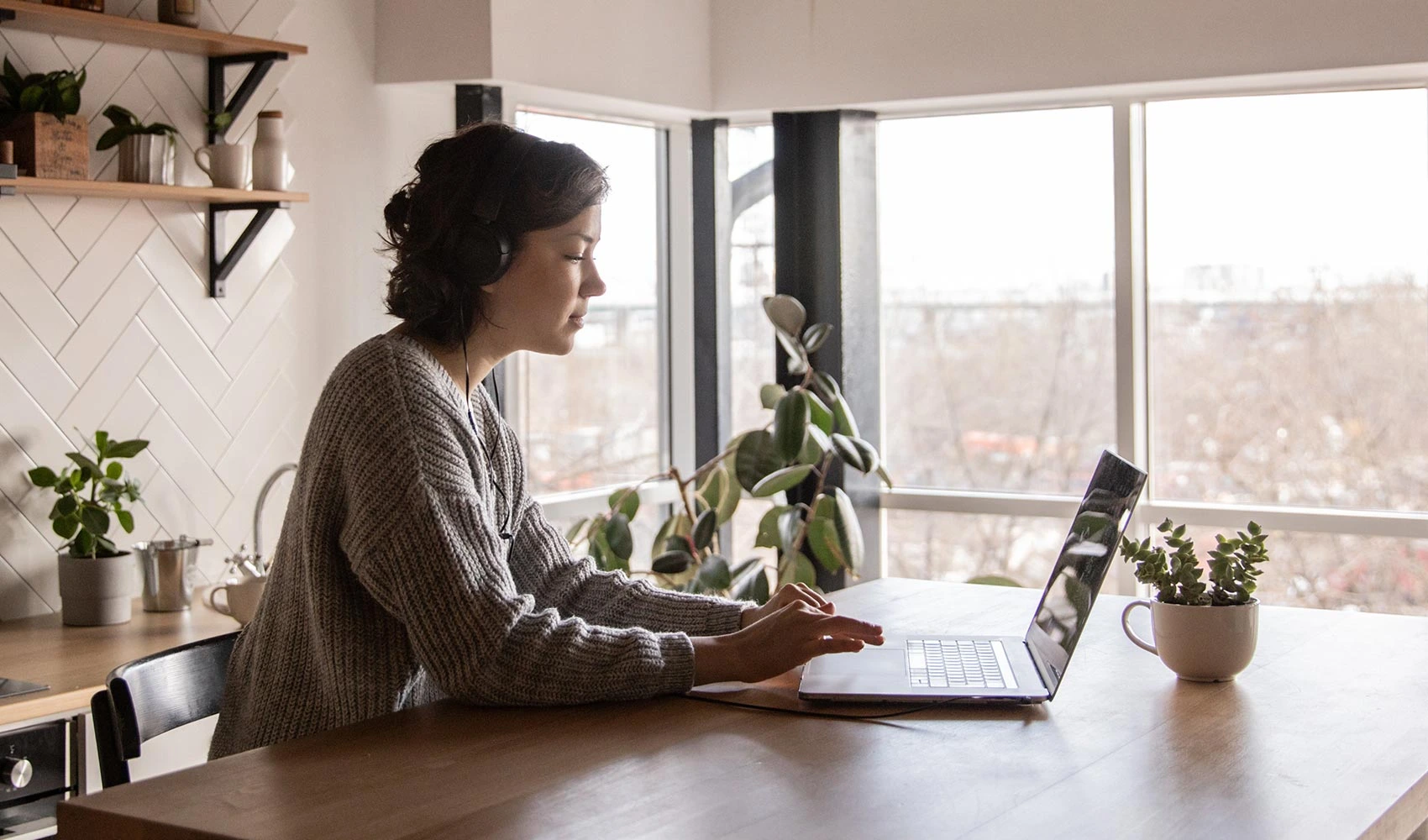 Young woman surfing laptop in kitchen