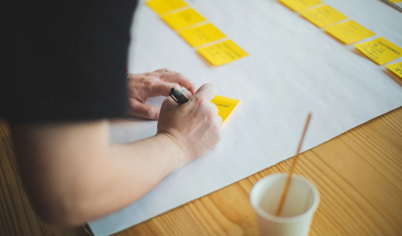 Person writing on a sticky note