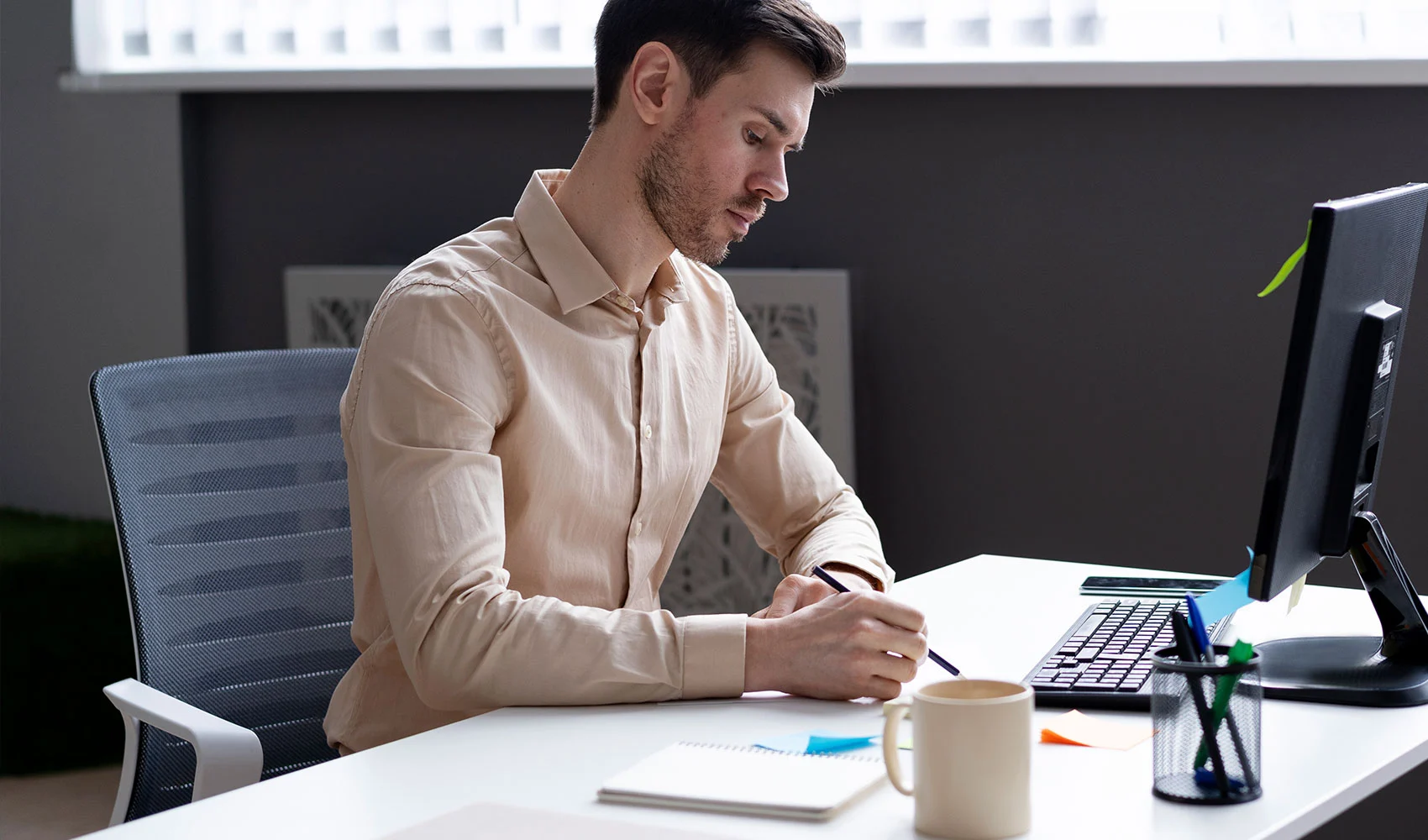 Man writing in-front of the computer