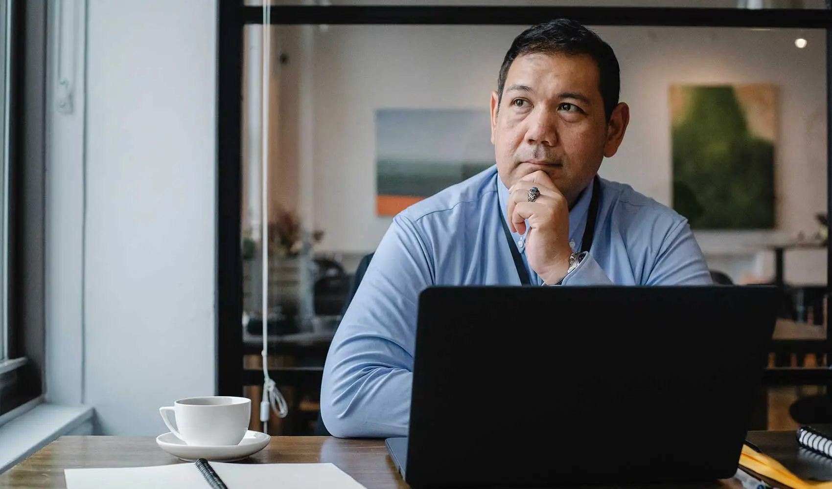 Thoughtful businessman using laptop while working