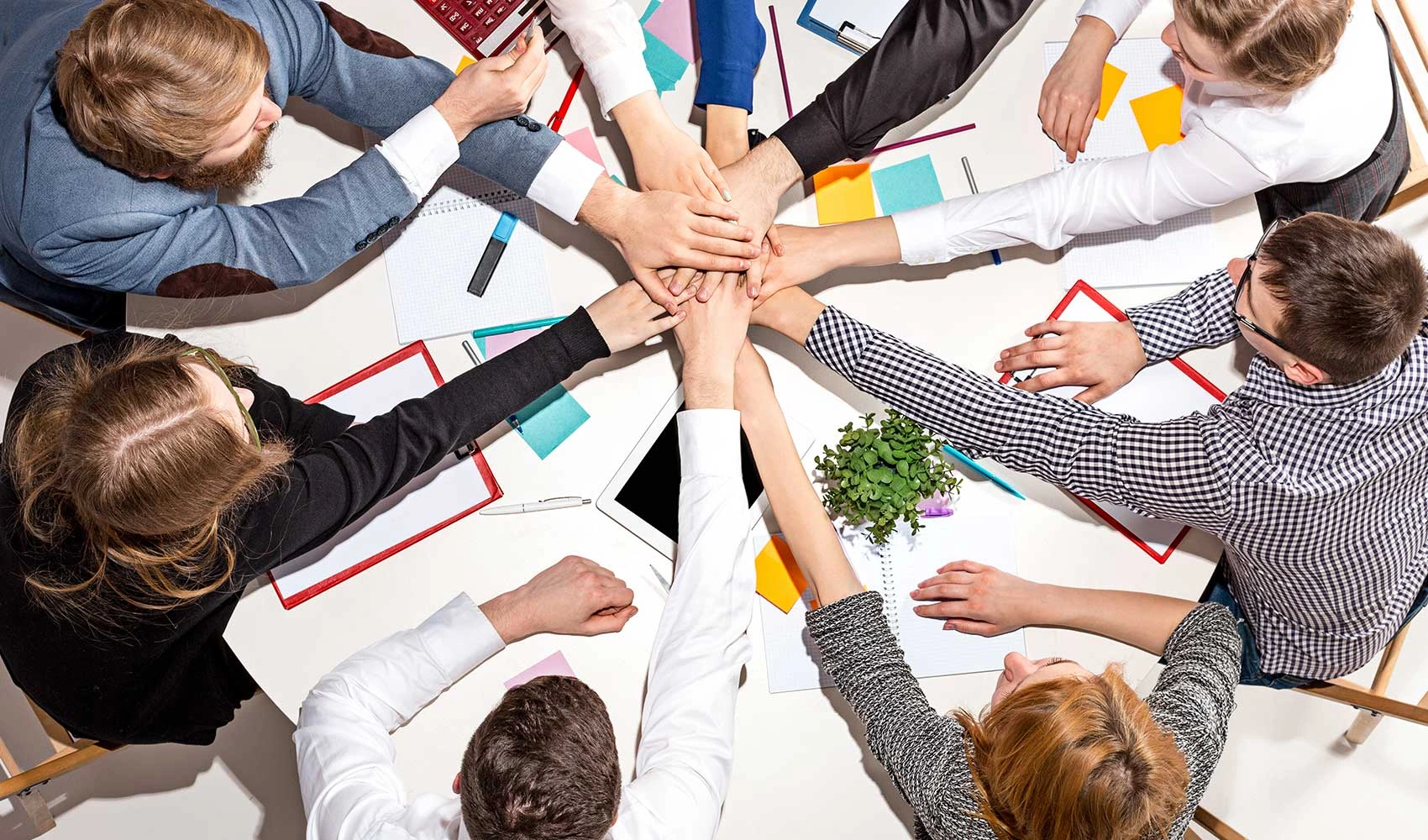 Top view of a team sitting and talking at the desk checking reports