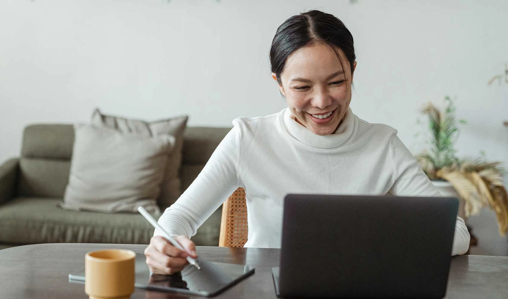 Woman working at home and making video call on laptop