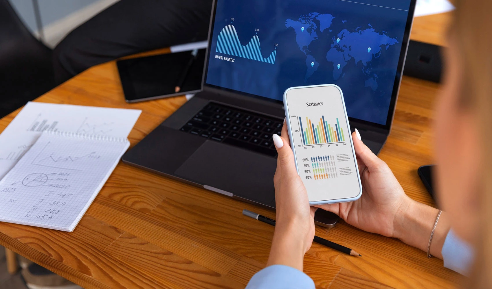 Laptop and mobile phone showing graphs and statistics