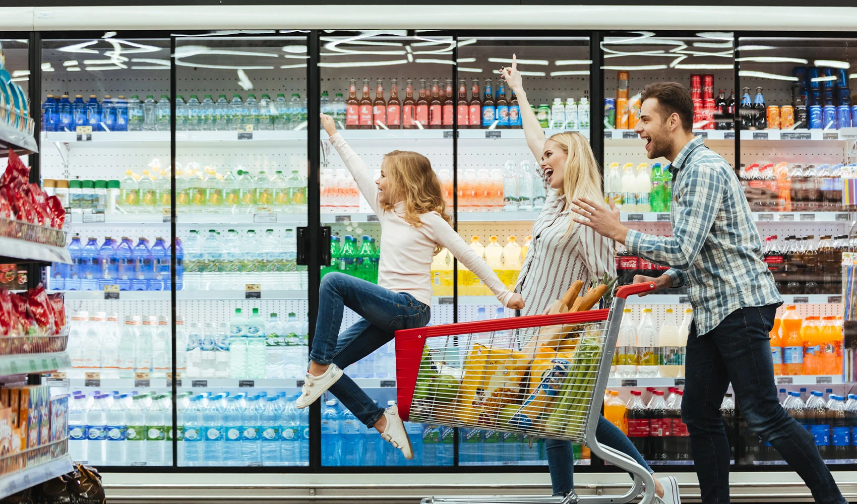 Happy family with child and cart at the supermarket