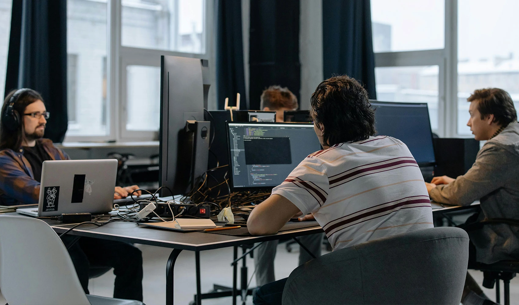 Men sitting at the desks in an office and using computers