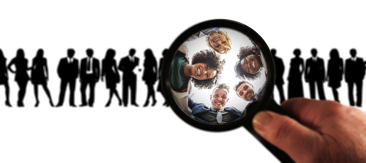 A person with a magnifying glass identifies a relevant audience of five people for their content marketing strategy.