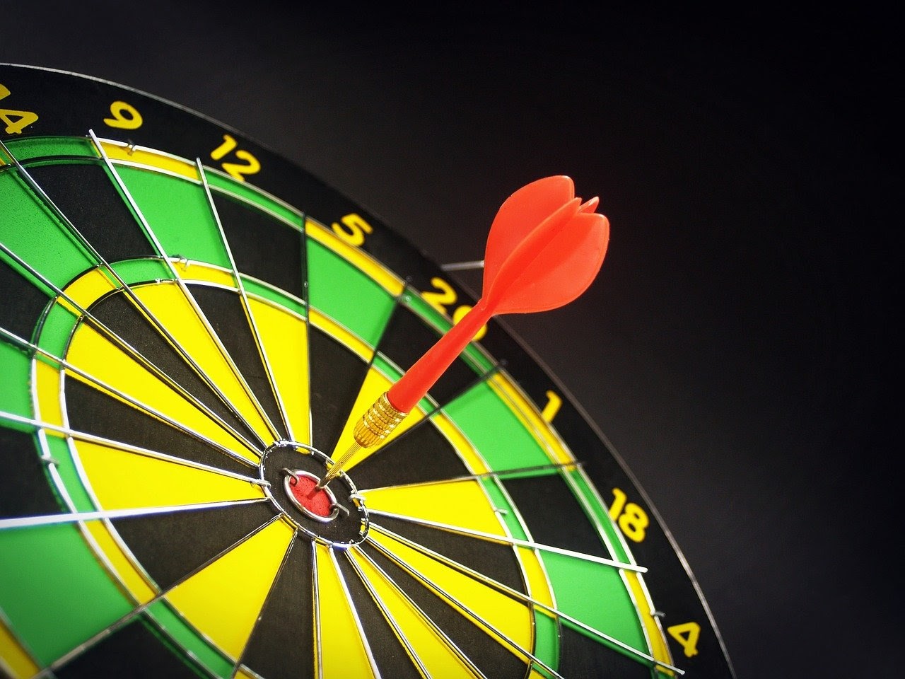 A dart within the bullseye range of a dartboard, which is a visualization of the effectiveness of segmentation for an email blast
