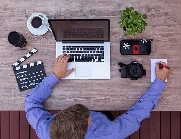 a man sets up his YouTube supplies and writes down a list of topics for his channel