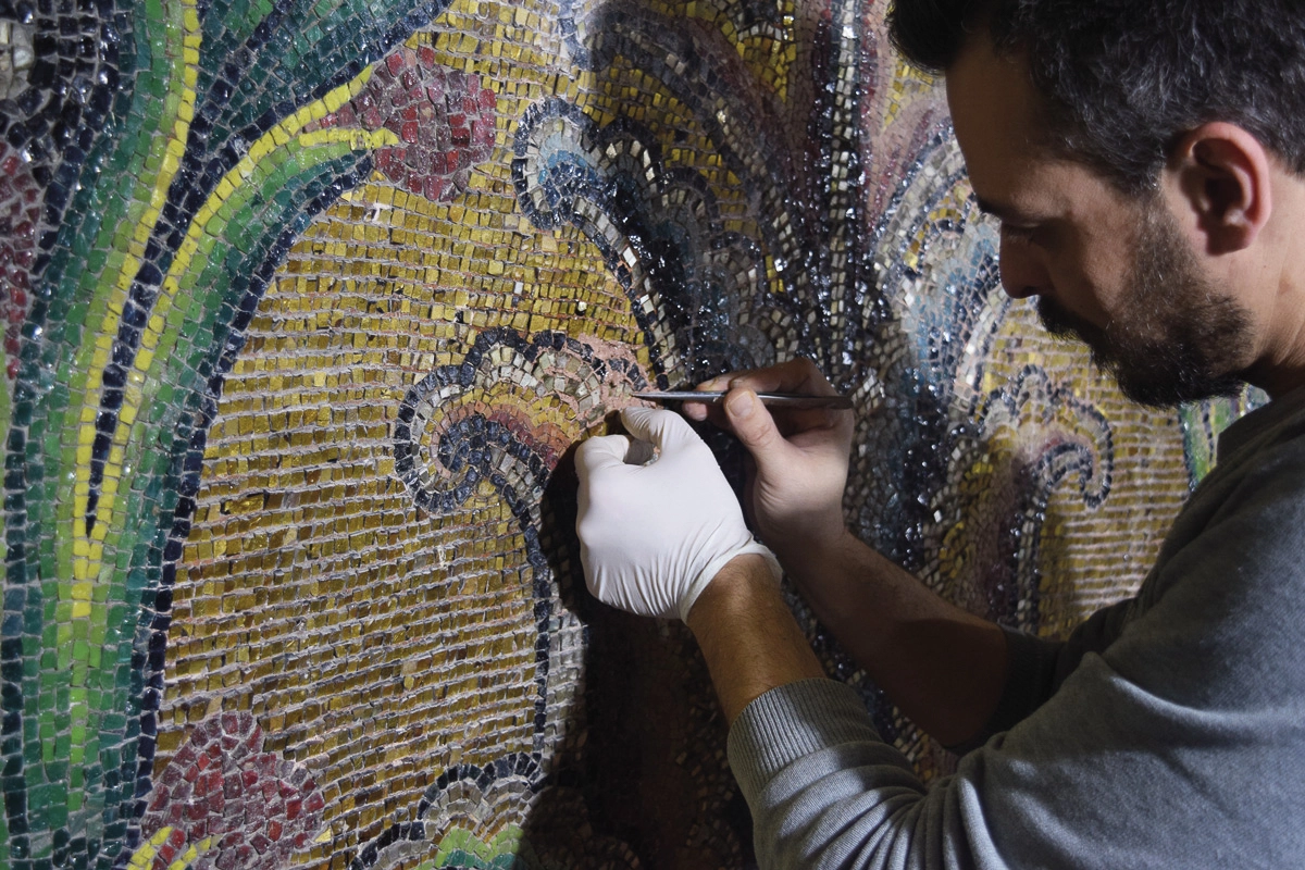 man restores an ancient mosaic
