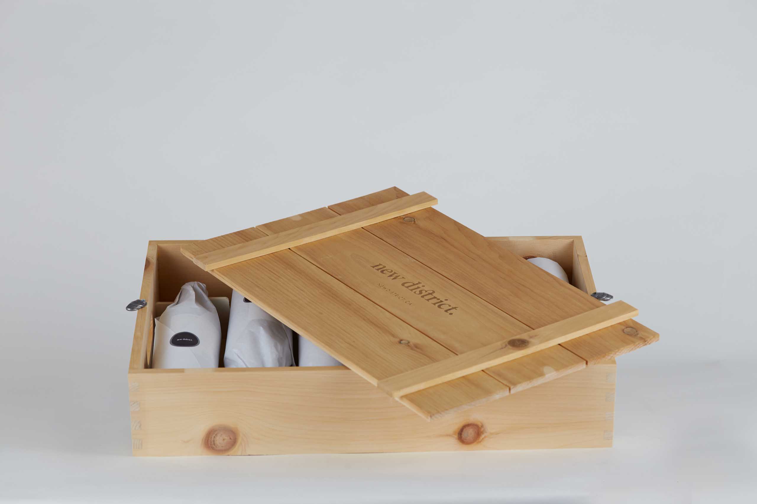 Wooden crate with lid partially closed with wrapped wine bottles inside — Yagnyuk.