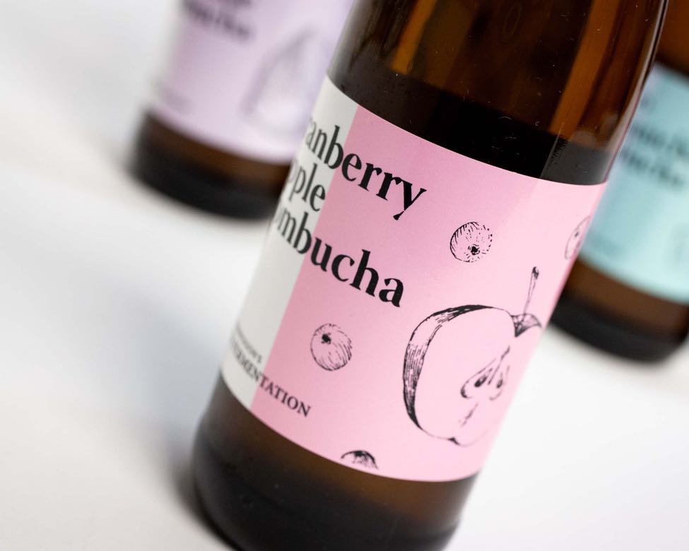 Close up of a thermal printed label for Kombucha bottle utilizing single color printing on top of Pantone matched label with apple illustration by Jessica Fraser — by Dima Yagnyuk.
