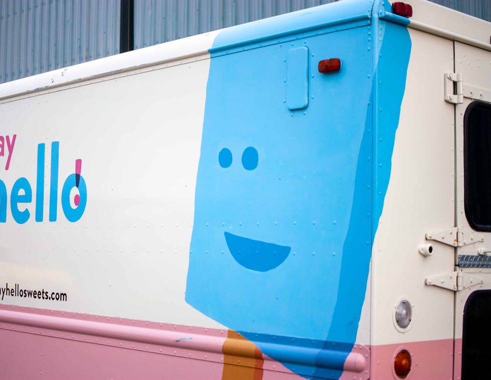 Say Hello Sweets truck featuring a handsigned, blue wrap around ice cream bar with a cartoon face — by Yagnyuk.