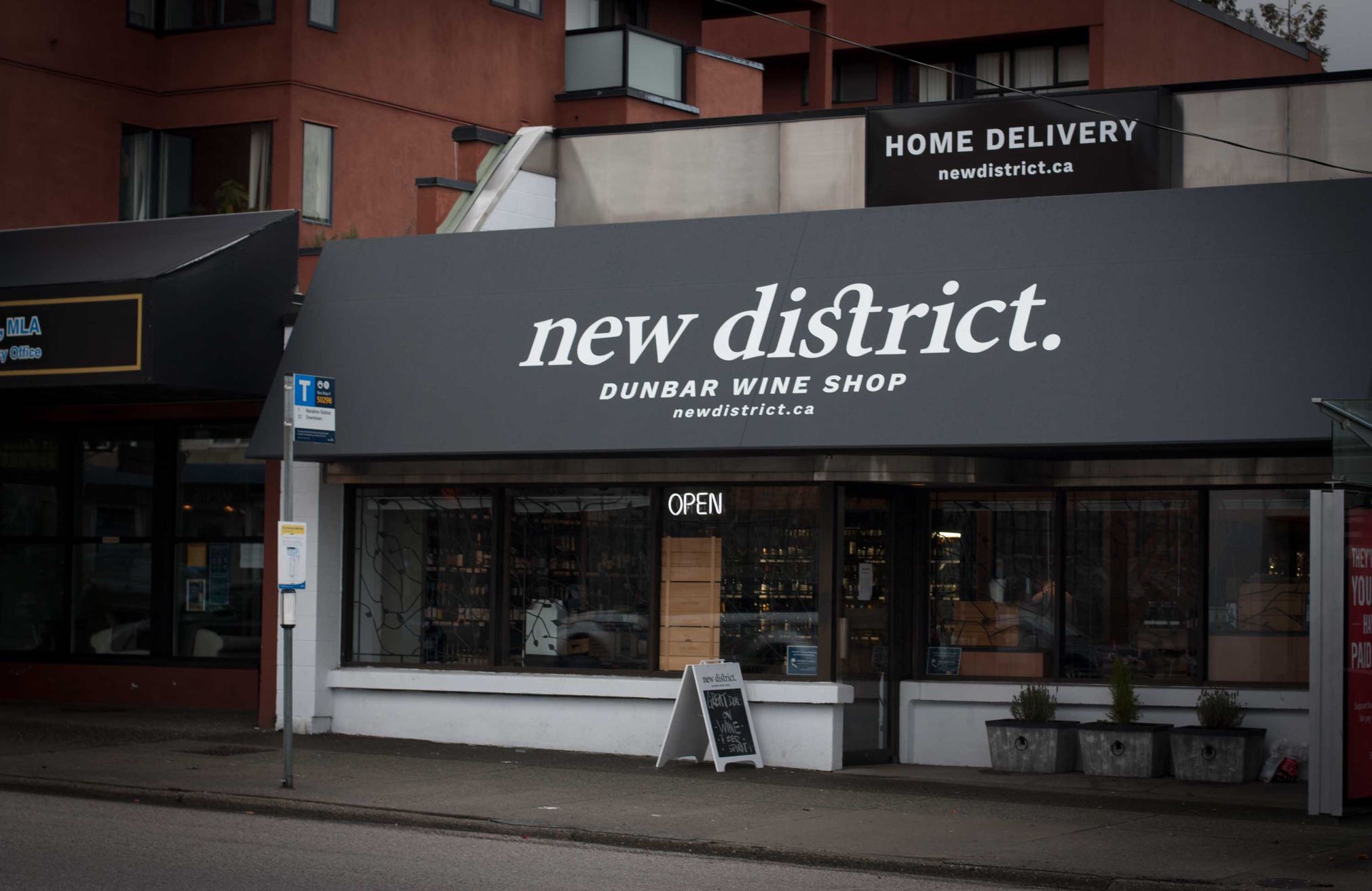 New District Storefront featuring black and white awnings with contrasting logo — by Yagnyuk.