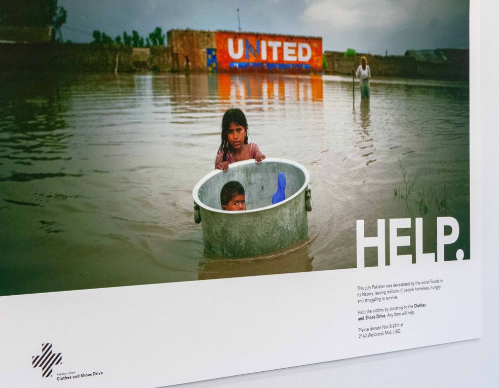 A young boy in a large pot, floating pushed by a young girl through a flooded town in Pakistan — by Dima Yagnyuk.