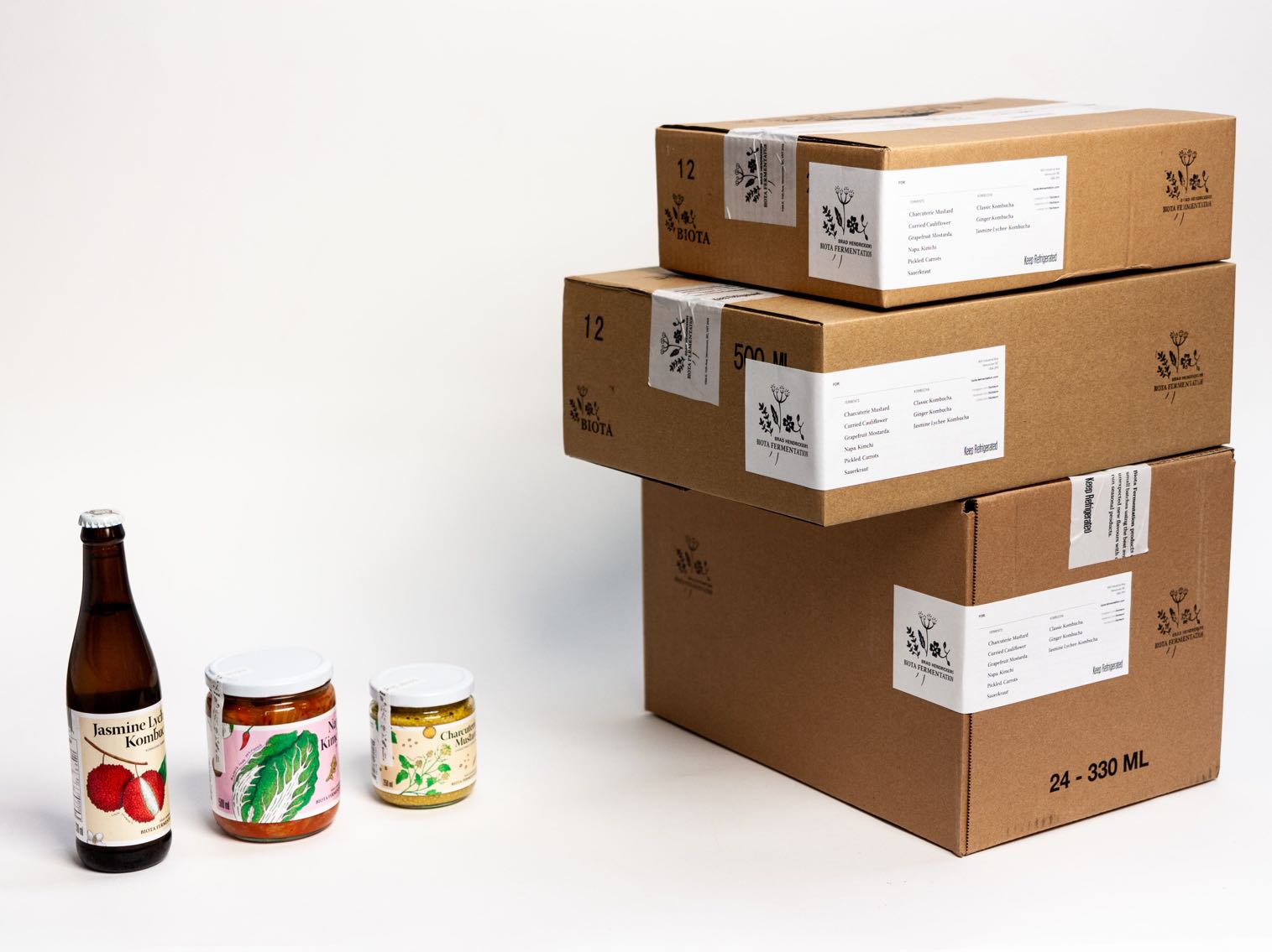Biota Fermentation Craft Shipping boxes with Custom branded tape, labels, and ink stamping creating a contrasting color, visually pleasing, informationally clear shipping box — by Dima Yagnyuk.