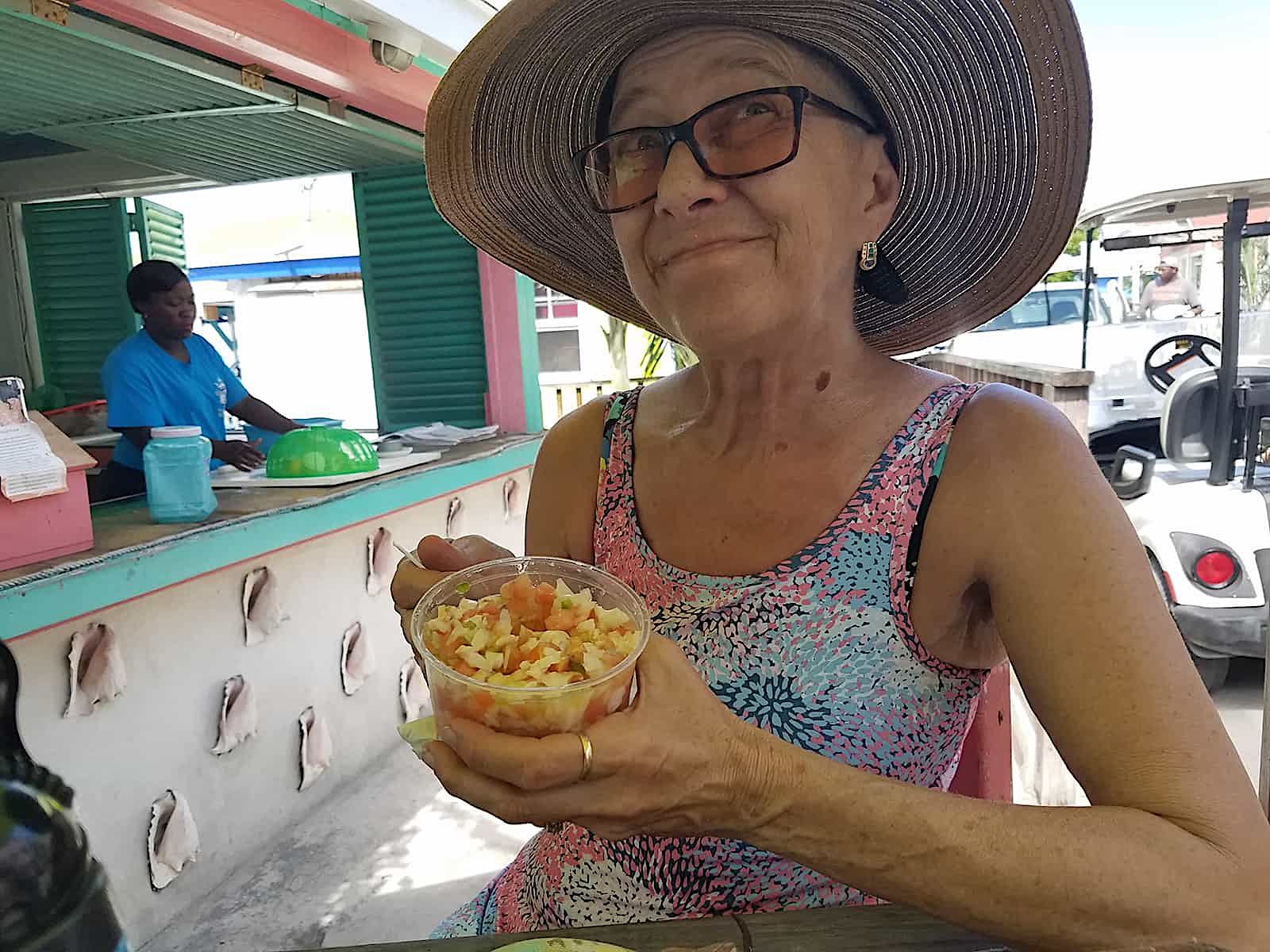 gail smiling and eating fruit salad on beach
