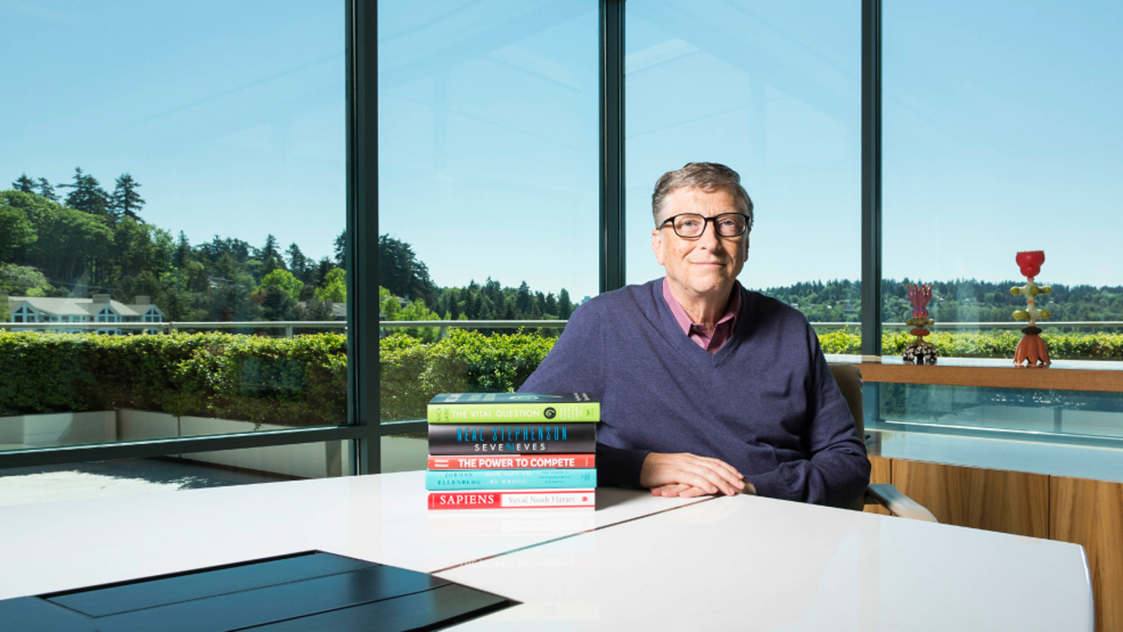 Bill Gates next to a stack of books