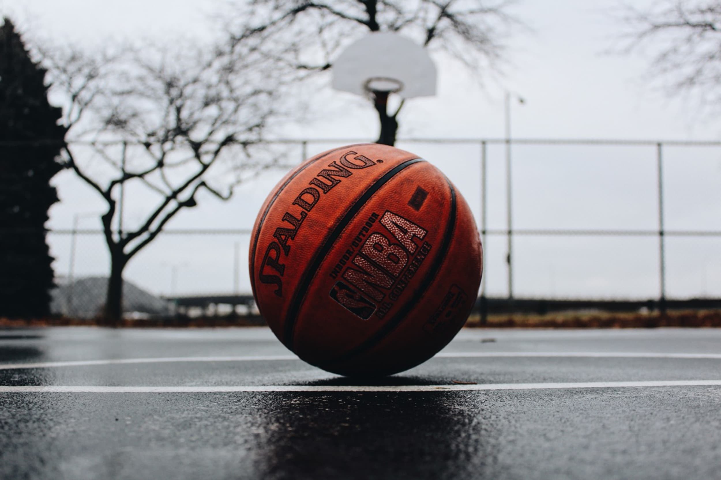 Spalding NBA basketball on a blacktop court on a rainy day