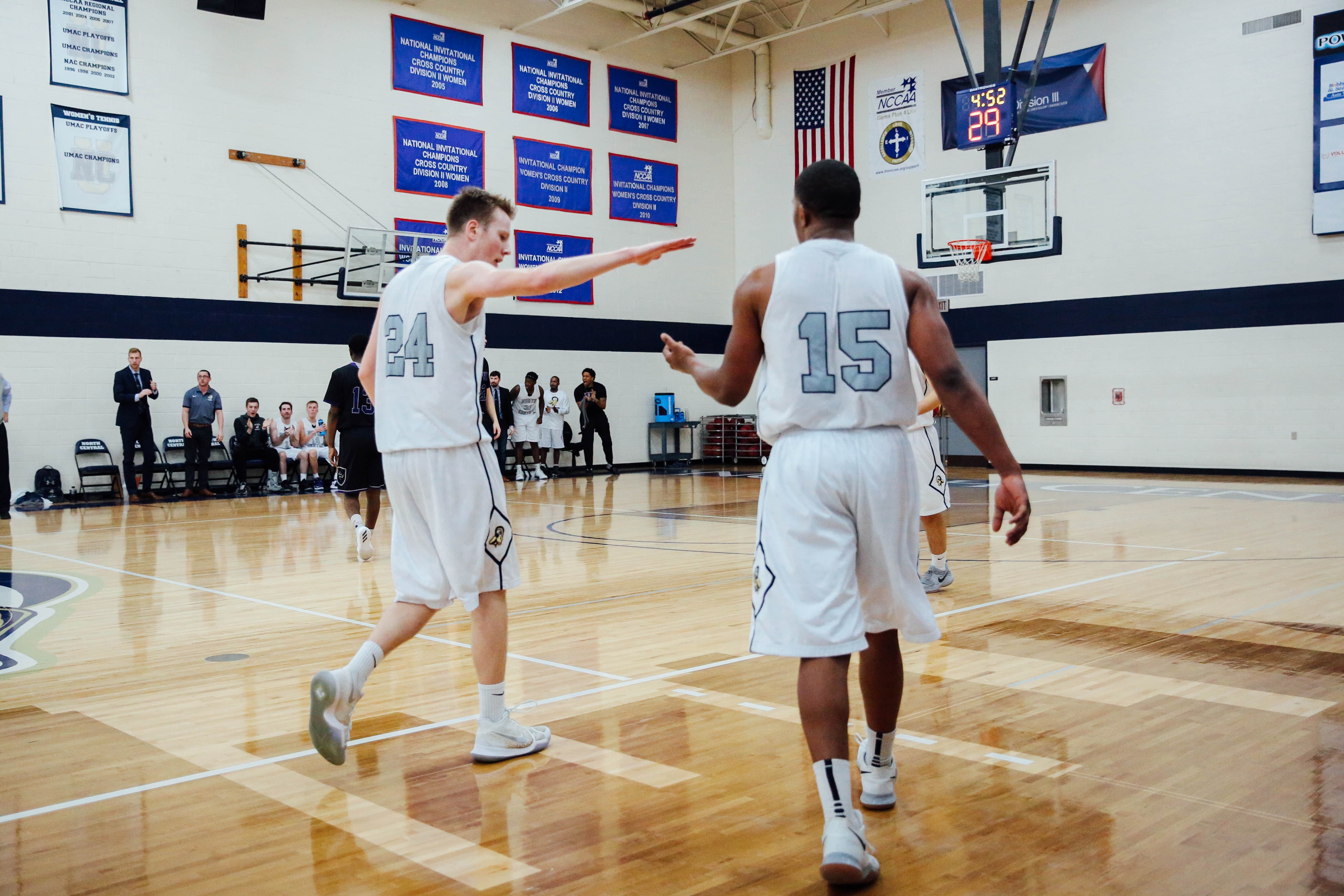 basketball teammates high five on indoor court