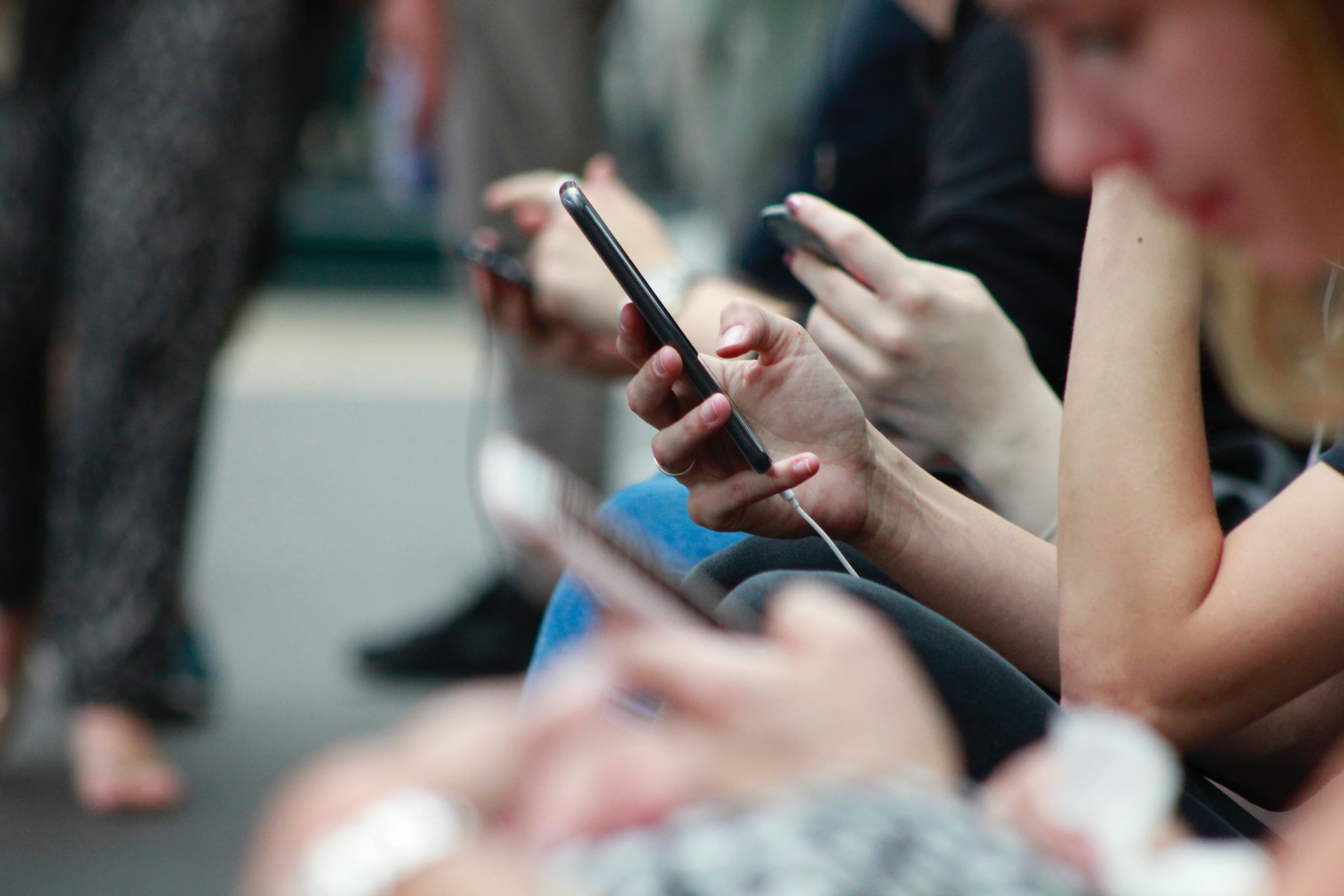 people sitting down on their phones