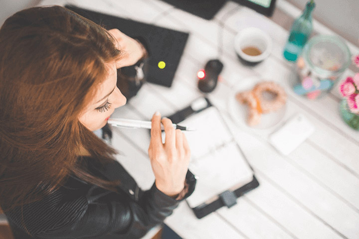 a woman sitting on her desk thinking