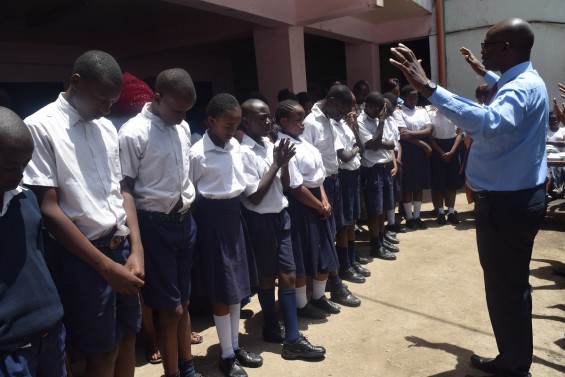 eduKenya Director, Bob Kikuyu, leads prayer for Class 8 students.