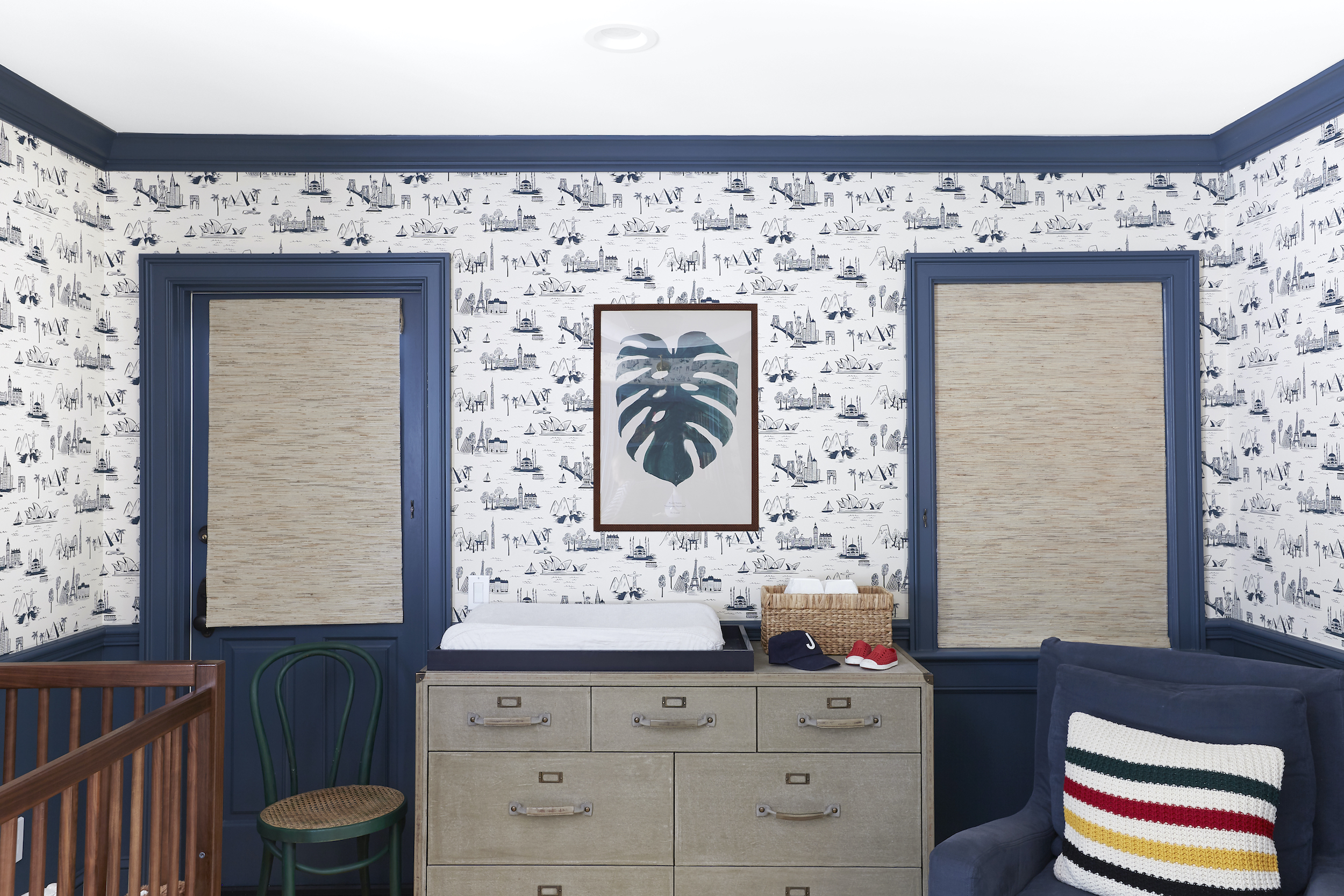 Closed woven wood shades on two windows provide almost 100% light blocking in this blue nursery