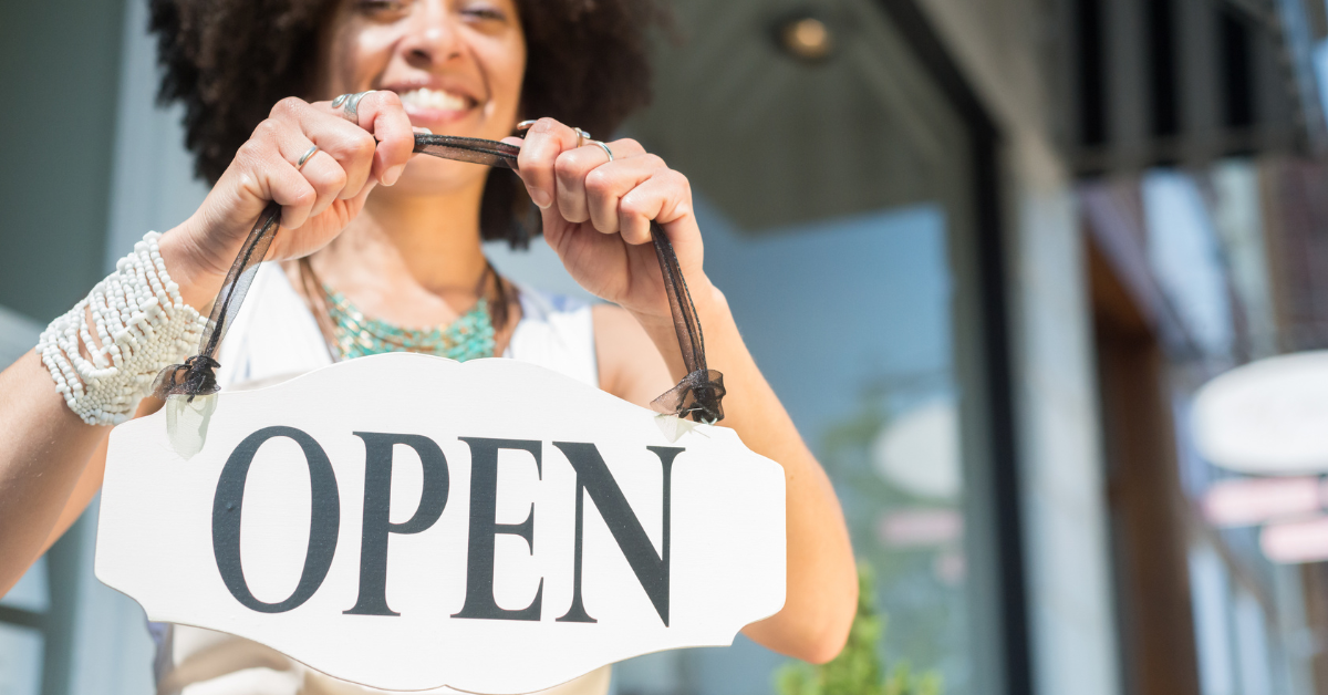 target market-based business owner holding an open sign
