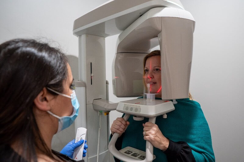 Patient getting x-ray with dental assistant