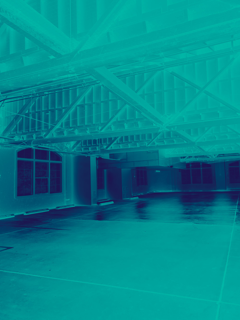 Image of an empty parking garage - there are a lot of steel beams overhead. The image is inverted and tinted in blue and purple