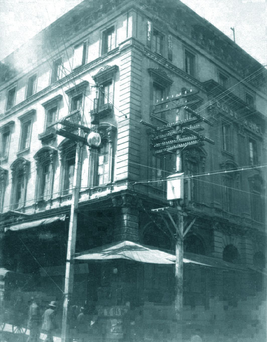 A photo of the Globe Theater taken from the street showing old telelphone and power lines at the street corner