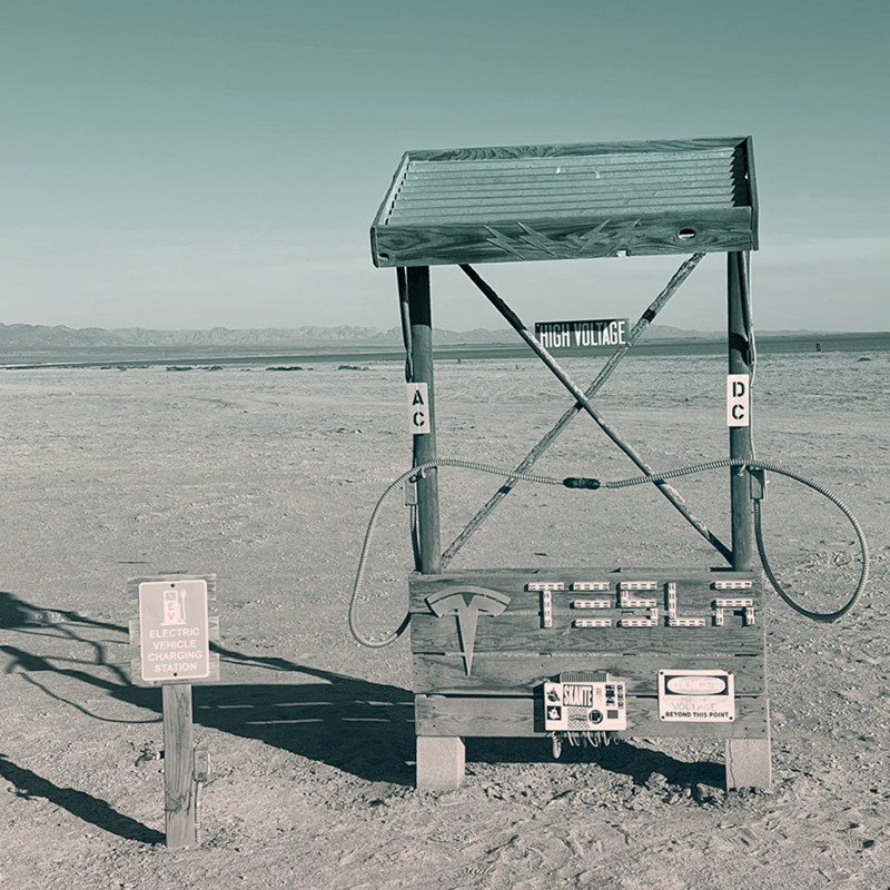 An art installation in the sand around the Salton Sea, CA - An extremely rustic looking "Tesla Charging Station" made out of scrap wood