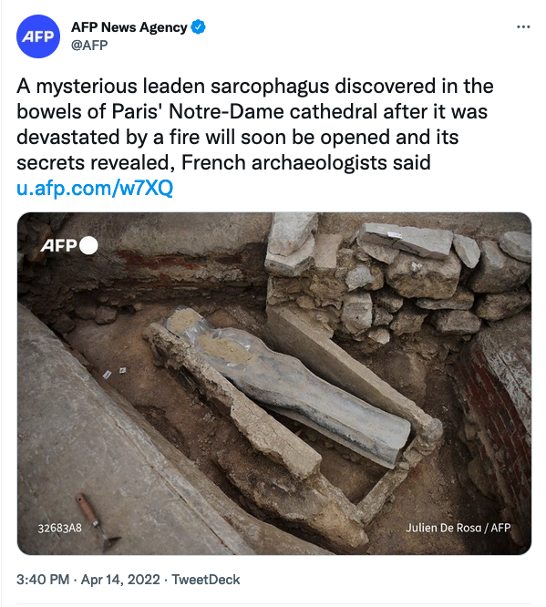 A screenshot of a tweet from AFP News Agency (@AFP) that reads "A Mysterious leaden sarcophagus discovered in the bowels of Paris' Notre-Dame cathedral after it was devastated by a fire will soon be opened and its secrets revealed, French archaeologists said." Below is a photo of a vaugely person-shaped metal container, resting amidst stone rubble