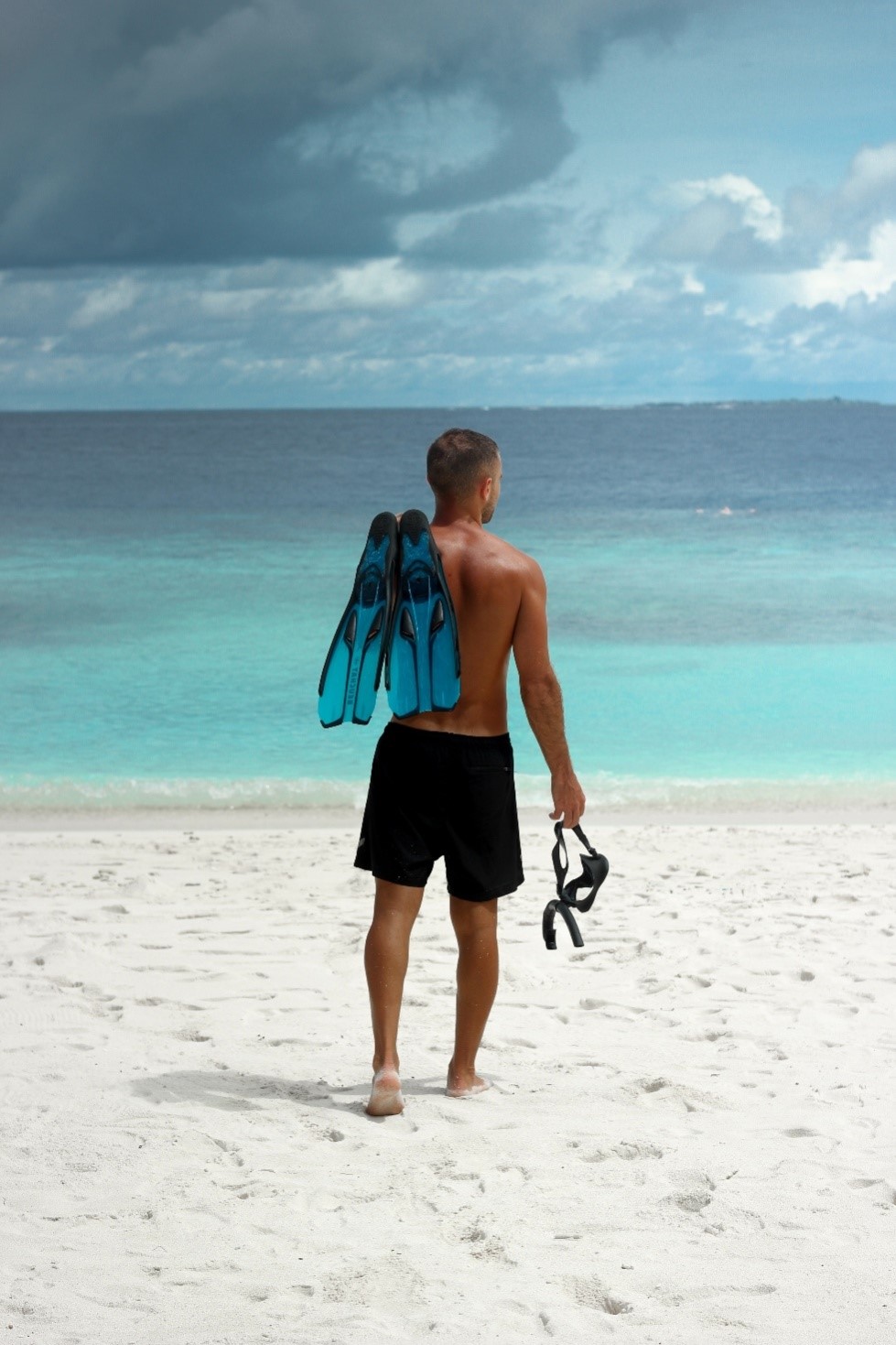 A person wearing black apparel shorts on the beach